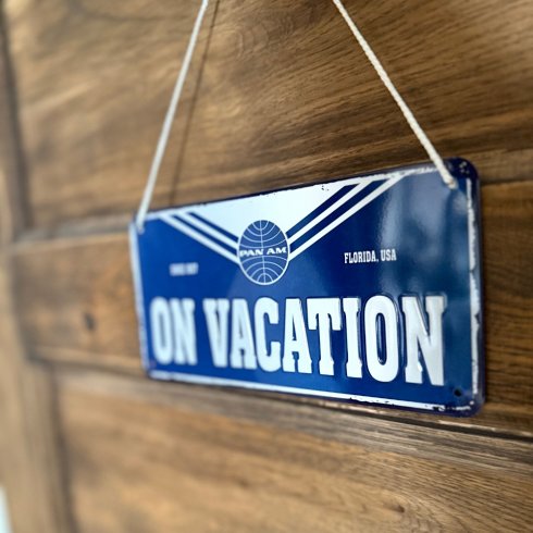 Metallskilt med henger «Pan Am – On Vacation»
