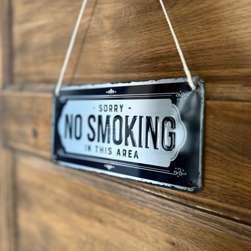 Metallskilt med hengende «sorry, no smoking»